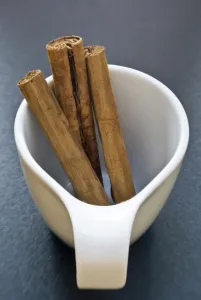 Sticks of cinnamon in small white cup credit: Marie-Louise Avery / thePictureKitchen