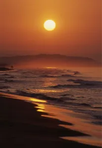 Sunrise over a southern Spanish beach, with a couple in the far distance. An alternative