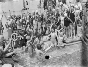 Bathing Wear Prints: The Swanscombe Baths in Kent. Children cheer as David Behar launches two inflatable