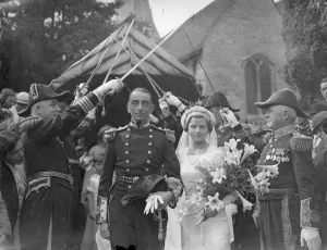 Tailors pull bridal car from church at Naval wedding in Kent village. Tailors towed