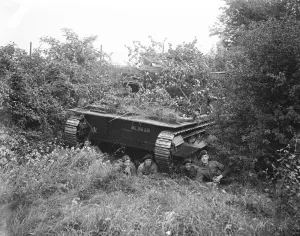 Manoeuvres Prints: A tank crew resting under a camouflaged tank. At the manoeuvres at Oxford. 5 September