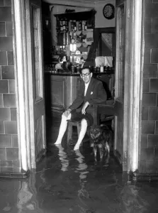Glasses Prints: Thames Floods At Belvedere licensee of the Belvoir sits in his bar and watches