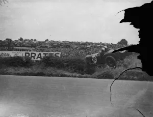 A thrill of the Ulster race. Remarkable photograph of motorcyclists car crashing