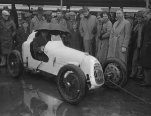 Umbrella as hood at rain sodden Brooklands. Heavy rain caused disappointment to