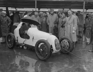 Umbrella as hood at rain sodden Brooklands. Heavy rain caused disappointment to