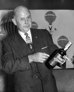International Herald Tribune Prints: Vice Admiral William J. Marshall holding a bottle of bourbon and a cigarette. 2