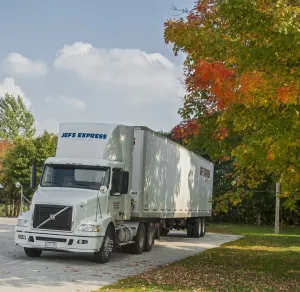 Volvo 6x4 day cab artic unit with a twin axle box trailer sat in glorious autumn