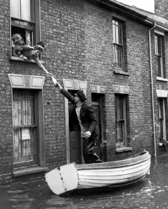 Bill Washford in a boat outside his house in Clyde Street Sheerness Kent fetch supples
