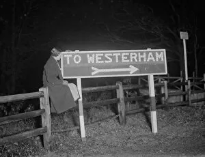 Sign Collection: Westerham road sign lit up at night. 1936