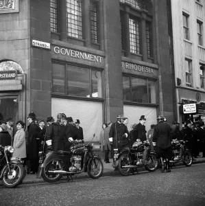 Demonstrations Demos Prints: The window blinds are drawn, and motor cycle and foot policemen stand guard outside