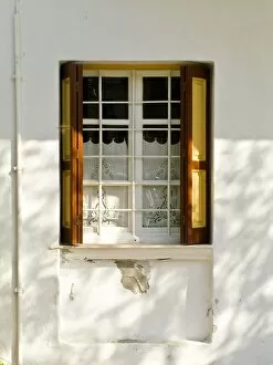 Tourist Collection: Window in white house in dappled sunlight with white embroidered cutwork curtain