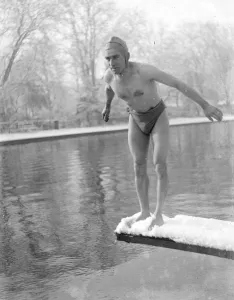 Outside Prints: Winter swimming. A man diveing into the cold water. He is standing on a snow-covered