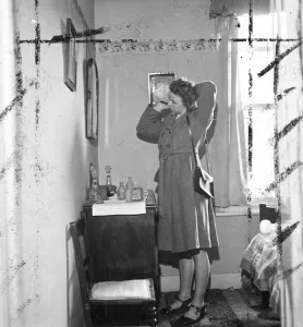 Mirror Prints: Woman brushing hair in front of the mirror in her bedroom. [no caption, location