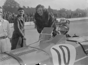 Woman driver at Brooklands autumn meeting. Miss D Evans ( standing ) talking to Mrs D G Evans