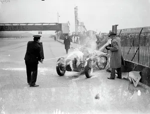 Woman driver leaps from blazing car at international trophy race. Miss Doreen Evans