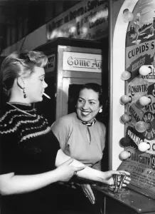 Smiling Prints: Two women enjoying themselves playing the Arcade machine Cupids Secret