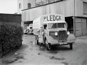 Transit Prints: A worker chats to the driver of a loaded Bedford truck belonging to Pledge & Son Ltd