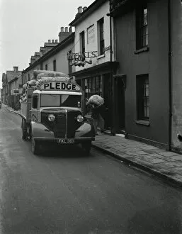 Workers Collection: Workers are unloading sacks of flour from a Bedford truck belonging to Pledge & Son Ltd