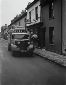 Workers are unloading sacks of flour from a Bedford truck belonging to Pledge & Son Ltd