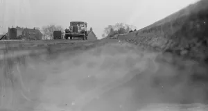 Workmen lay the foundations for road banking along the edges of the road in Farningham