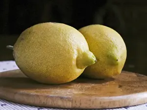 Citrus Prints: Two whole yellow lemons from Majorca on wooden board credit: Marie-Louise Avery