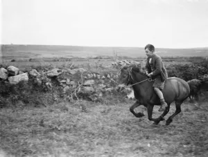A young boy rides a horse bareback. 1936