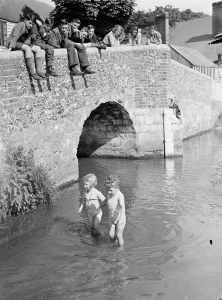 Young children paddle in the ford by the Eynsford humpback bridge over the River