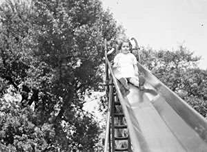 Playing Collection: A young girl on a slide in Dartford, Kent. 1939